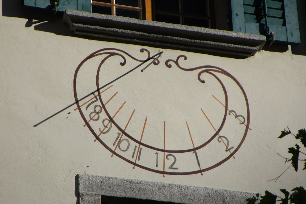 Wanduhr an einem Wohnhaus in Promontogno GR